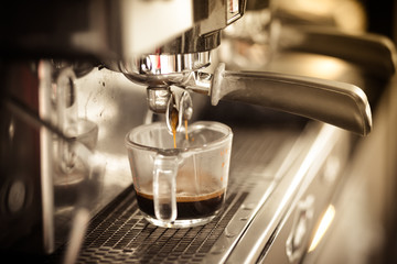 Professional coffee machine preparing cup of coffee.