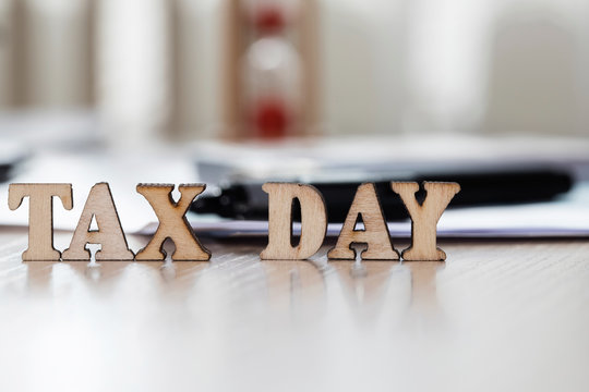 Word TAX DAY composed of wooden letters. Closeup