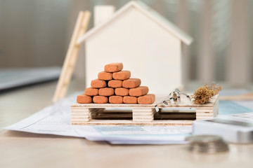 Red bricks for construction, mini rakes and sweeper on a small wooden pallet.