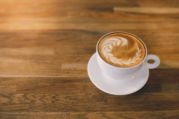 A Cup of hot latte art coffee on wooden table