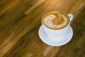 A Cup of hot latte art coffee on wooden table