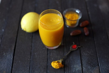 water with turmeric on dark wooden background