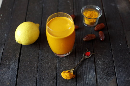 Water With Turmeric On Dark Wooden Background