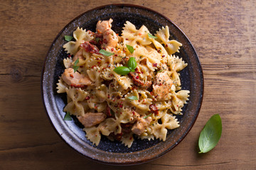 Sun dried tomato pasta with chicken and basil in creamy mozzarella sauce. View from above, top studio shot