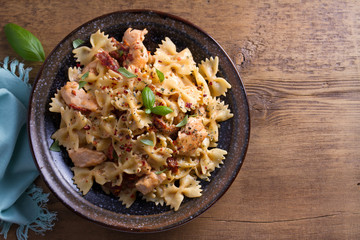 Sun dried tomato pasta with chicken and basil in creamy mozzarella sauce. View from above, top studio shot