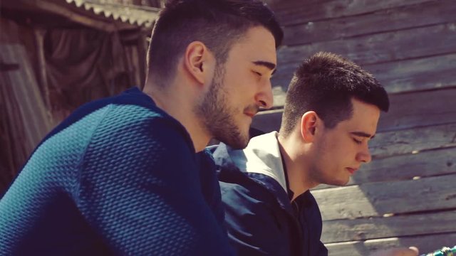 Young boys smoke electronic cigarettes in the streeet