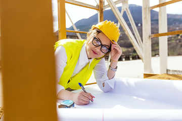 Busy female architect working on plans