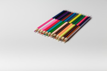 many colored pencils on the white table