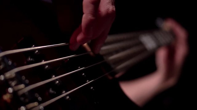 Musician playing five string electric bass guitar macro