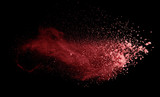 Abstract colored red powder explosion isolated on black background.