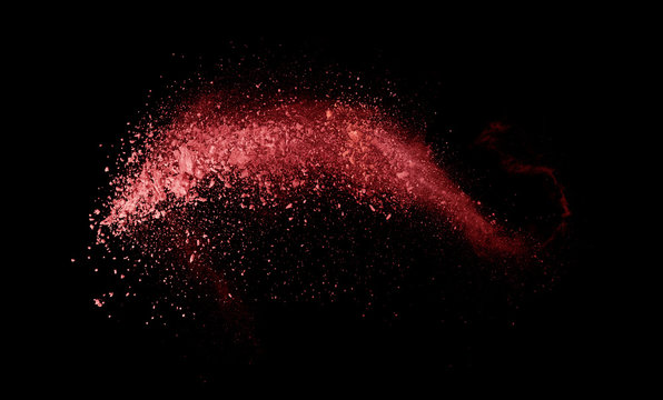Abstract colored red powder explosion isolated on black background.