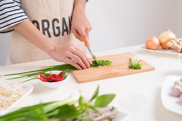 Female chef prepare traditional Vietnamese soup Pho bo with herbs, meat, rice noodles