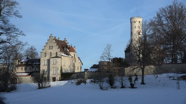 Establishing shot from the south side of castle Lichtenstein in Swabia, Germany, bathed in stunningly beautiful early morning light on a cold winter`s day.