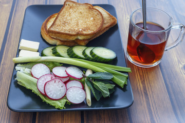 radish, onion, cucumber, spices, toast and tea as Breakfast on wooden background.