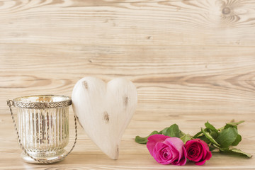 Ein Herz mit zwei Rosen vor einem Holz Hintergrund