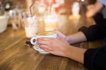 Female hands holding cup of coffee.