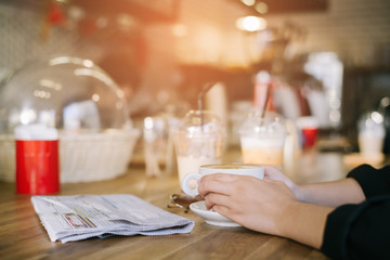 Female hands holding cup of coffee.
