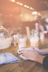 Female hands holding cup of coffee.