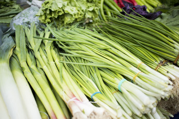 Green salad and onion, garlic, herbs on the market for sale.