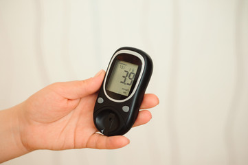 glucometer with result of measurement sugar level and tape measure, concept of diabetes
