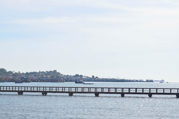 Fototapeta premium Walkway cement bridge over the sea and shore background