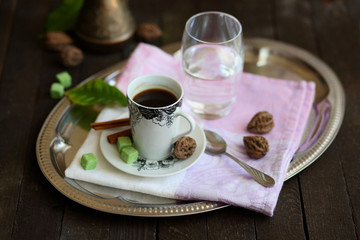 espresso Cup, Turk, glass of water on a tray on a dark wooden table.