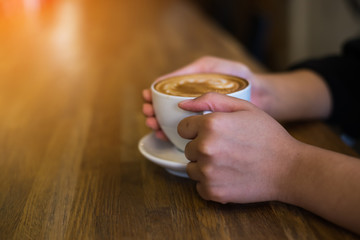 Female hands holding cup of coffee.