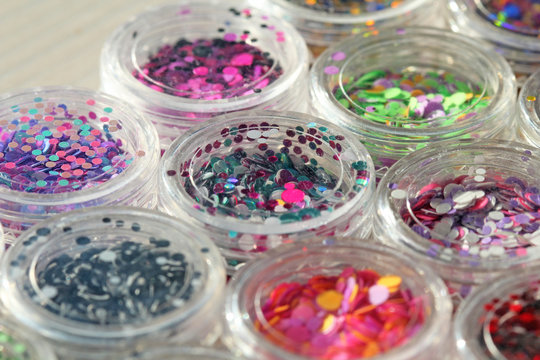 Multi Colored Sequins For The Design Of Nails In A Jar. Glitter In Jars. Foil For Nail Service. Photo Set. Sparkling Beauty Shimmer, Glitter. Bright Background Of Glitter. Top View