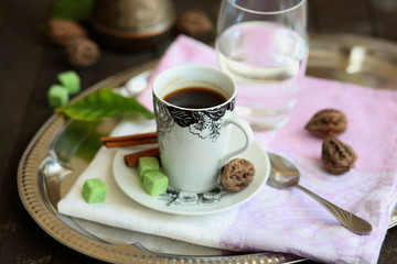 espresso Cup, Turk, glass of water on a tray on a dark wooden table.