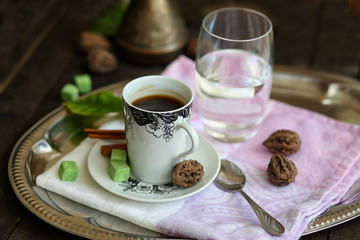 espresso Cup, Turk, glass of water on a tray on a dark wooden table.