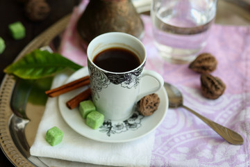 espresso Cup, Turk, glass of water on a tray on a dark wooden table.