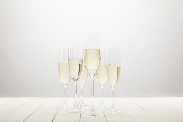 closeup view of champagne glasses on white wooden table