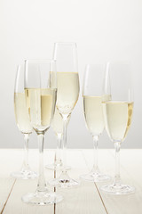 closeup view of champagne glasses on white wooden table