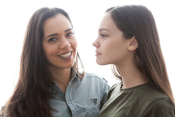 Two sisters standing near each other over white background