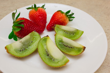 Strawberry and slices of kiwi  on the white plate