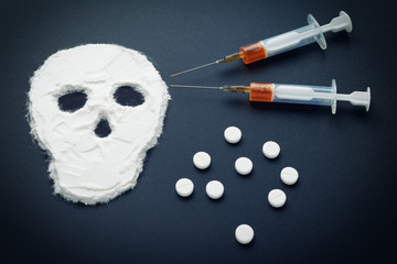 Narcotic powder in the form of a skull and syringes with injection. The concept of addiction kills.