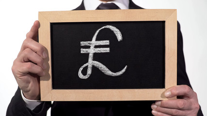 Pound symbol drawn on blackboard in businessman hands, British currency, finance