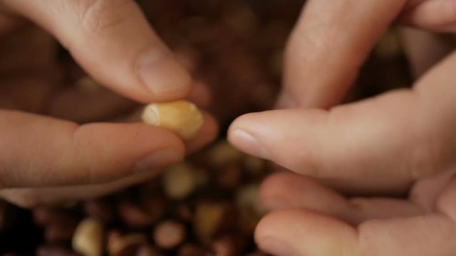 Man cleans roasted peanuts. Close-up.