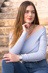 Obraz premium Young girl portrait sitting on stairs in park