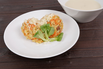 Risotto with carrot and cheese on table