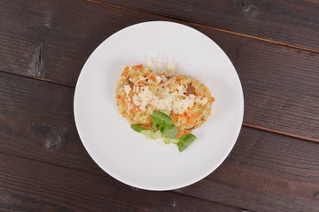 Risotto with carrot and cheese on table