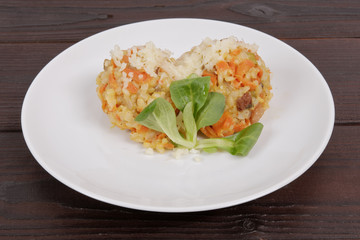 Risotto with carrot and cheese on table