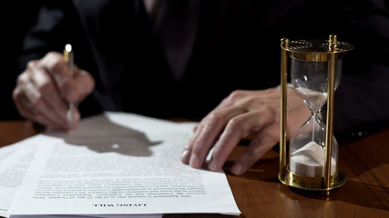 Terminally ill man signing living will before medical care, leaving heritage