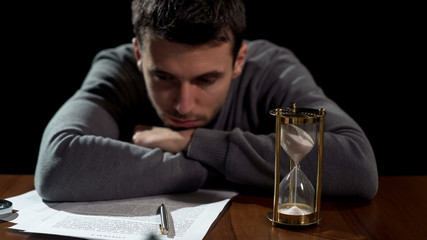 Doubtful young man uncertain about signing document, starting risky business