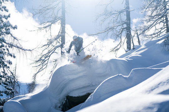 Male skier jumping off a cliff in fresh powder snow, Zauchensee, Salzburg, Austria