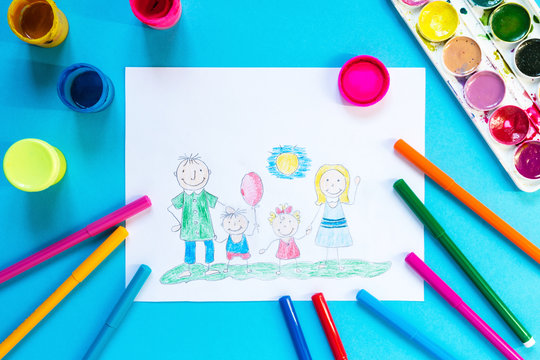 Childrendrawing pencil happy family mom, dad, son, daughter sunny day on the lawn and paint accessories, brush, felters gouache, watercolor on a blue background flat lay top view from above