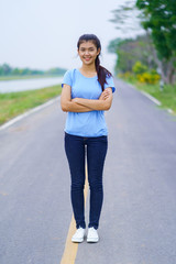 Portrait of beautiful girl in blue t-shirt and jeans standing in the outdoors