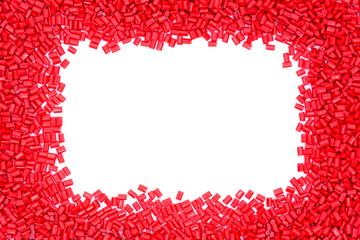 Red plastic polymer granules on white background.