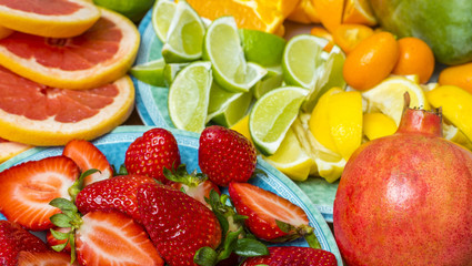 Variation of beautiful ripe fruit on a kitchen table, orange, lemon, lime, grapefruit, strawberry