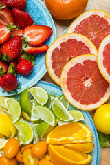 Fototapeta na wymiar Variation of beautiful ripe fruit on a kitchen table, orange, lemon, lime, grapefruit, strawberry